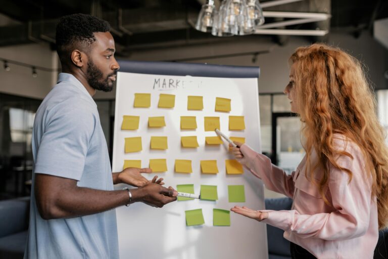 Two marketing team colleagues brainstorming ideas for a content strategy in a collaborative workspace.